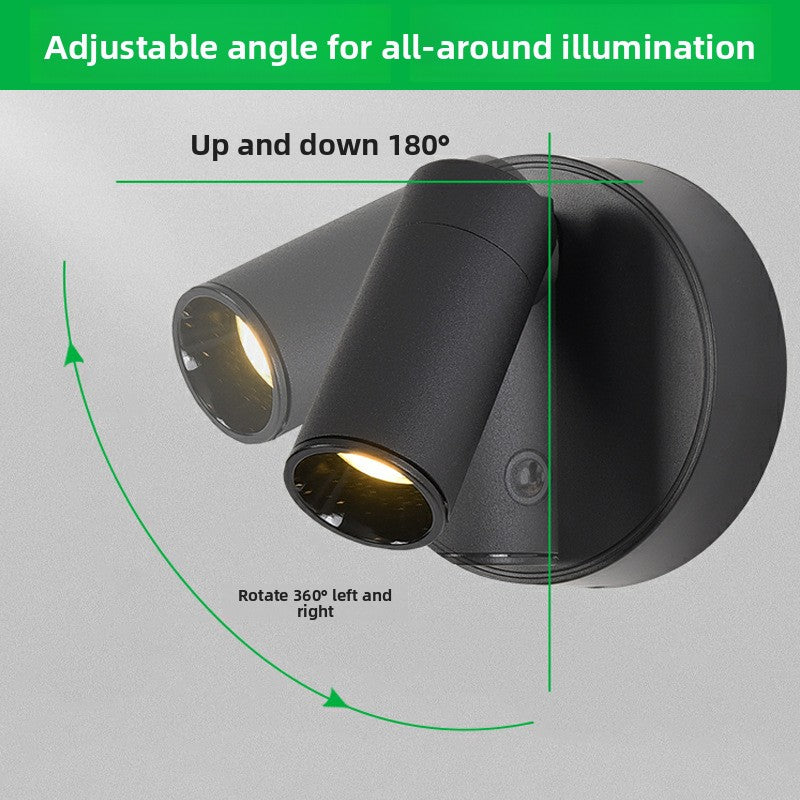 Black round wall lamp with warm LED light turned on
