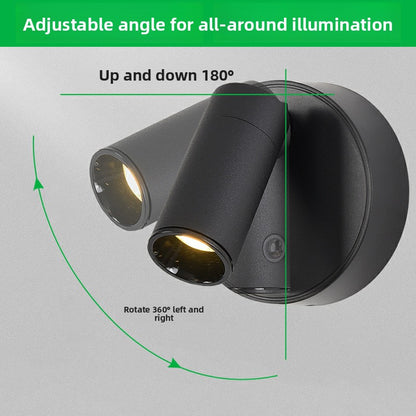 Black round wall lamp with warm LED light turned on
