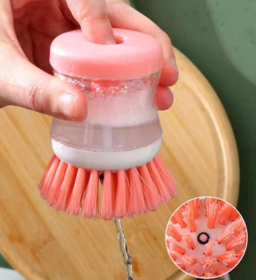 Soap dispensing dish brush cleaning a plate in the sink

